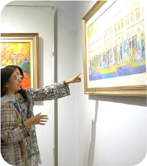 Visitor adjusting artwork on gallery wall